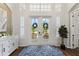 Inviting foyer with a decorative rug, a white cabinet, and a view of the manicured front yard at 13115 Harriers Pl, Bradenton, FL 34212
