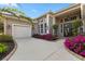 Inviting home exterior with a driveway, lush landscaping, a well-manicured lawn, and a charming front entrance at 13115 Harriers Pl, Bradenton, FL 34212
