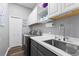 Well-organized laundry room featuring modern washer and dryer, ample counter space, and overhead cabinetry at 13115 Harriers Pl, Bradenton, FL 34212