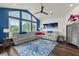 Bright living room with a statement blue wall, vaulted ceiling, fan, and a large seating area at 13115 Harriers Pl, Bradenton, FL 34212