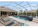 Relaxing screened-in pool area featuring lounge chairs, a spa, and outdoor seating at 13115 Harriers Pl, Bradenton, FL 34212