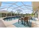 Screened-in pool area with a dining table, lounge chairs, and a relaxing view of tropical plants at 13115 Harriers Pl, Bradenton, FL 34212