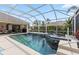 Relaxing pool area with a waterfall, tiled accents, patio furniture, and lush landscaping for outdoor enjoyment at 13115 Harriers Pl, Bradenton, FL 34212