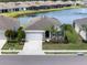 A high angle showcases a well maintained single-story home on a lake with a fountain at 13915 Mount Laurel Trl, Bradenton, FL 34211