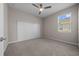 Bright bedroom with a ceiling fan, plush carpeting, and modern horizontal wood plank accent wall at 13915 Mount Laurel Trl, Bradenton, FL 34211