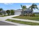 Charming single-story home with a two car garage, stone accents, palm trees and a well-manicured lawn at 13915 Mount Laurel Trl, Bradenton, FL 34211