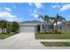Charming single-story home with a two car garage, stone accents, palm trees and a well-manicured lawn at 13915 Mount Laurel Trl, Bradenton, FL 34211