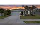 Charming single-story home with a two car garage, stone accents, palm trees and a well-manicured lawn at sunset at 13915 Mount Laurel Trl, Bradenton, FL 34211