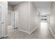 Hallway featuring neutral paint, tile flooring, and views of the backyard water at 13915 Mount Laurel Trl, Bradenton, FL 34211