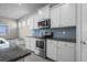 Stylish kitchen featuring stainless steel appliances, white cabinets, and a blue tiled backsplash at 13915 Mount Laurel Trl, Bradenton, FL 34211