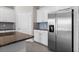 Kitchen boasts stainless steel refrigerator, white cabinetry, and granite counters at 13915 Mount Laurel Trl, Bradenton, FL 34211