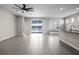 Open concept living room with lake view, tile floors, ceiling fan, and kitchen counter seating at 13915 Mount Laurel Trl, Bradenton, FL 34211