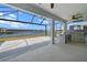 A covered patio has an outdoor kitchen with grill and view of the lake at 13915 Mount Laurel Trl, Bradenton, FL 34211