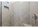 Close up of shower featuring designer tiles, shower head, and corner seat at 13915 Mount Laurel Trl, Bradenton, FL 34211