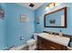Stylishly decorated powder room with blue walls, classic fixtures, and well-lit mirror at 1612 Shady Leaf Dr, Valrico, FL 33596