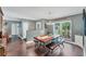 Cozy dining room with a farmhouse table, wooden floors, and view of entryway and a large window at 1612 Shady Leaf Dr, Valrico, FL 33596