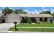 Charming single-story home featuring well-manicured lawn and landscaping under a blue sky at 1612 Shady Leaf Dr, Valrico, FL 33596