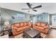 Inviting living room featuring comfortable leather sofas, stylish decor, and a modern ceiling fan for optimal comfort at 1612 Shady Leaf Dr, Valrico, FL 33596