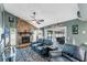 Inviting living room with a stone fireplace, ceiling fan, and views of the enclosed pool area at 1612 Shady Leaf Dr, Valrico, FL 33596