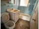 Small, outdated bathroom with blue tiling, vanity, toilet and bathtub at 1758 35Th St, Sarasota, FL 34234