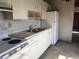 Outdated kitchen with white cabinets, white refrigerator and dated tile flooring at 1758 35Th St, Sarasota, FL 34234