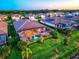 An aerial view showcases the home's backyard pool, screened patio, and manicured yard in a friendly neighborhood at 17728 Polo Trail, Lakewood Ranch, FL 34211