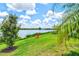 Well manicured lawn leading to a lake with a chair on the water's edge at 17728 Polo Trail, Lakewood Ranch, FL 34211
