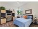 Bright bedroom equipped with desk and built-in shelving in addition to a wooded floor at 17728 Polo Trail, Lakewood Ranch, FL 34211