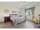 Comfortable bedroom features tray ceilings, updated fixtures, and hardwood flooring at 17728 Polo Trail, Lakewood Ranch, FL 34211