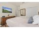 Well-lit bedroom features wood floors, a large TV, and ample closet space at 17728 Polo Trail, Lakewood Ranch, FL 34211