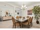 Elegant dining area with neutral tile flooring, an eye-catching chandelier, and plenty of natural light at 17728 Polo Trail, Lakewood Ranch, FL 34211