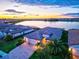 Exterior shot of a home with a beautiful lake view at sunset, featuring well-manicured landscaping and curb appeal at 17728 Polo Trail, Lakewood Ranch, FL 34211