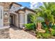 Home's grand entrance features a stone facade, brick pathway, and landscaping with a water fountain at 17728 Polo Trail, Lakewood Ranch, FL 34211