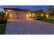 Inviting home exterior features a paver driveway, two-car garage, and lush landscaping at 17728 Polo Trail, Lakewood Ranch, FL 34211