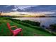 Breathtaking lake view at sunset from lush green lawn with a relaxing chair at 17728 Polo Trail, Lakewood Ranch, FL 34211