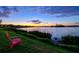 Scenic lake view at sunset, featuring a comfortable chair on the grassy bank to enjoy the view at 17728 Polo Trail, Lakewood Ranch, FL 34211