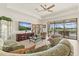 Comfortable living room with neutral tile flooring, ceiling fan, and view of the pool at 17728 Polo Trail, Lakewood Ranch, FL 34211