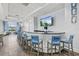 Bright lounge area featuring a curved bar with comfortable blue chairs, hardwood floors, and a large screen television at 17728 Polo Trail, Lakewood Ranch, FL 34211