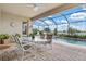 Covered patio with dining set overlooking a screened pool and water view at 17728 Polo Trail, Lakewood Ranch, FL 34211