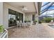 Covered patio with an outdoor dining set, ceiling fan, and access to the pool area at 17728 Polo Trail, Lakewood Ranch, FL 34211