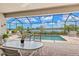Screened lanai featuring a beautiful pool and spa with lake views and outdoor dining area at 17728 Polo Trail, Lakewood Ranch, FL 34211