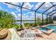 Relaxing poolside with a lounge chair, cocktail table and a view of the lake at 17728 Polo Trail, Lakewood Ranch, FL 34211
