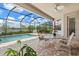 Outdoor living space with a sparkling pool, brick patio, and a dining area under a ceiling fan at 17728 Polo Trail, Lakewood Ranch, FL 34211