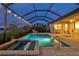 Screened-in pool and spa area illuminated with string lights for evening enjoyment at 17728 Polo Trail, Lakewood Ranch, FL 34211