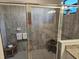 This tiled shower includes a chrome door and frame with two decorative stools at 17728 Polo Trail, Lakewood Ranch, FL 34211