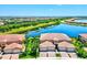 Stunning aerial view of the community highlighting beautiful homes, a serene lake, and lush landscaping at 23528 Awabuki Dr # 101, Venice, FL 34293