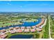 An aerial view featuring a community built around a pond and golf course with a lush green landscape at 23528 Awabuki Dr # 101, Venice, FL 34293
