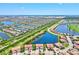 An aerial view of a community with many homes, multiple ponds, and a golf course under a sunny blue sky at 23528 Awabuki Dr # 101, Venice, FL 34293