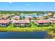 Scenic aerial view of townhomes showcasing stunning water views, a lake, and beautifully maintained landscaping at 23528 Awabuki Dr # 101, Venice, FL 34293