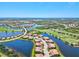 An aerial view of an expansive community featuring winding roads, numerous ponds, and a lush green golf course at 23528 Awabuki Dr # 101, Venice, FL 34293